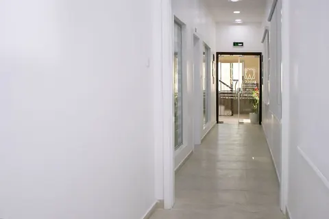 A bright corridor leading to the clinic's glass entrance