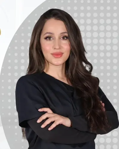 Portrait of Dr. Shurooq Al-Mashour in black clinic scrubs, arms folded